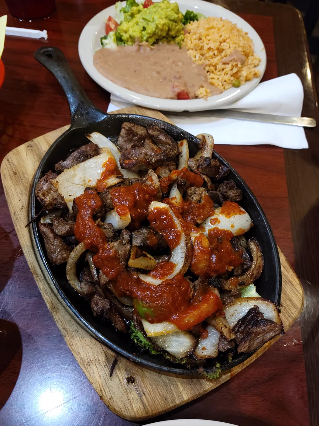 A sizzling meat and onion dish photographed at El Dorado Restaurant